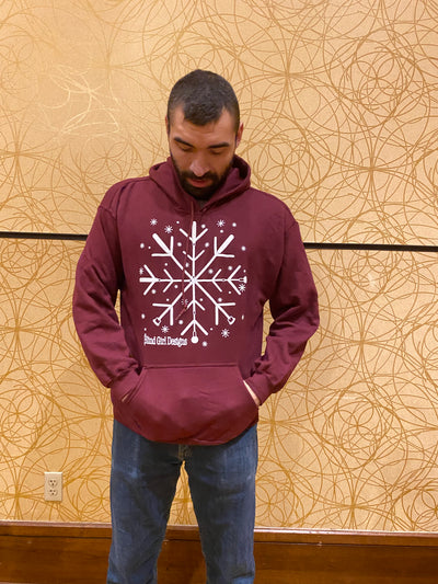This is a classic, unisex hoodie sweatshirt. There is a large 12 by 12 chest print of a white 3D puff ink snowflake made of crossing 4 blind canes. They are crossed like a spoke. Each spoke has 2V shapes, which gives it the snowflake outlook. There are tiny 3D snowflakes sprinkled around the main snowflake. It is a standard hoodie pullover sweatshirt fit with a large front pocket and large hood.