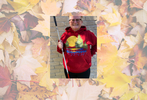 Tricia in a deep red hoodie with the Minnesota state ACB design. She is against a background of fall leaves.