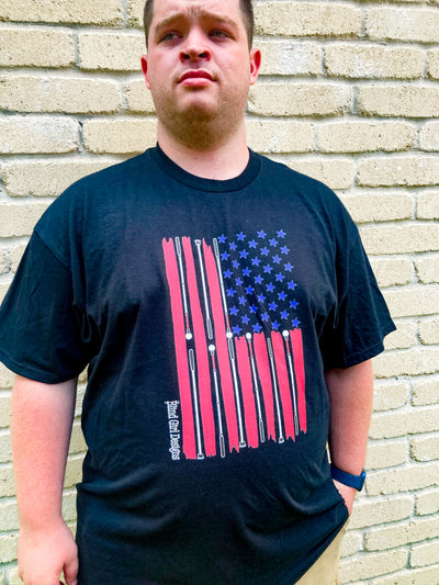 Robert is wearing an extra large black t-shirt. He is 5 foot 8 inches and extra large is his normal size. It is a cool impression of the American flag. There are 50 blue stars, and red stripes that taper at the edges. The white stripes are made from a variety of white cane styles.